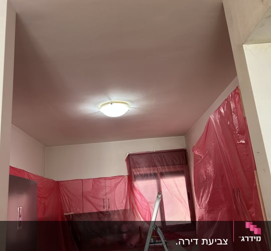 סולם וחיפוי פלסטיק אדום בעבודת שיפוץ